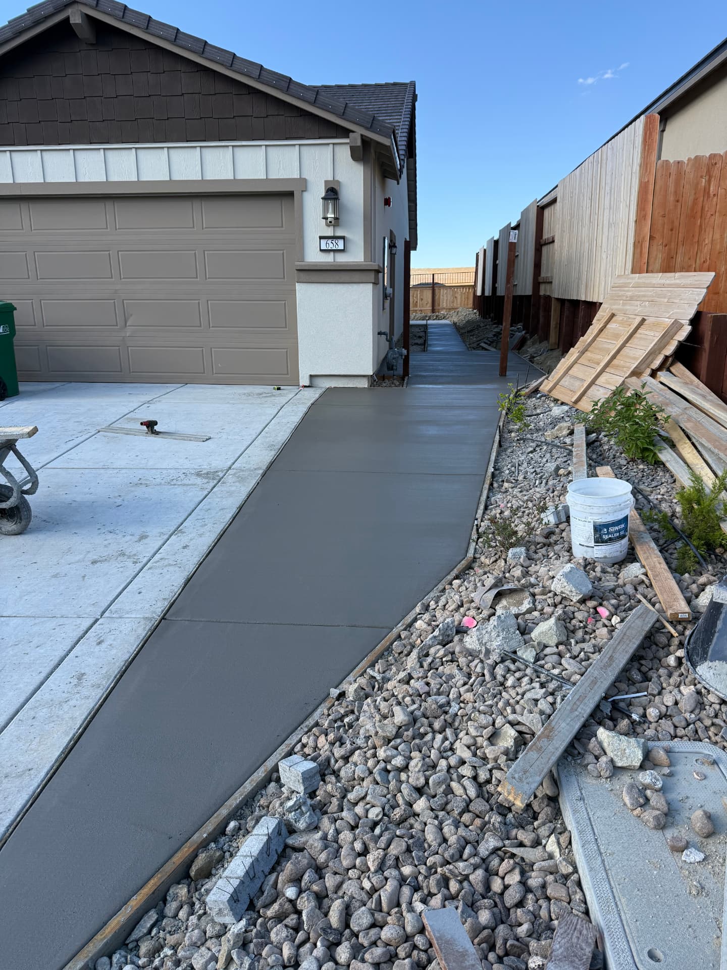 New concrete walkway poured from the driveway along the garage