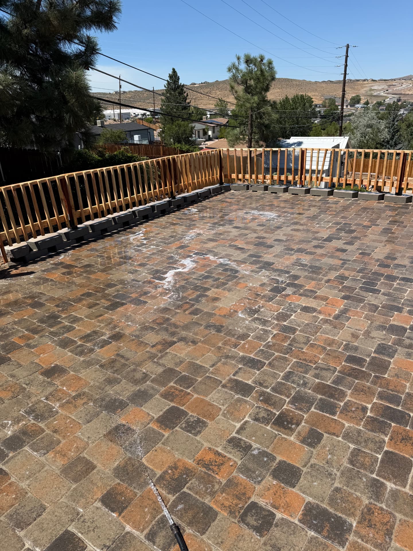 Freshly washed paver patio with cedar railing overlooking the valley
