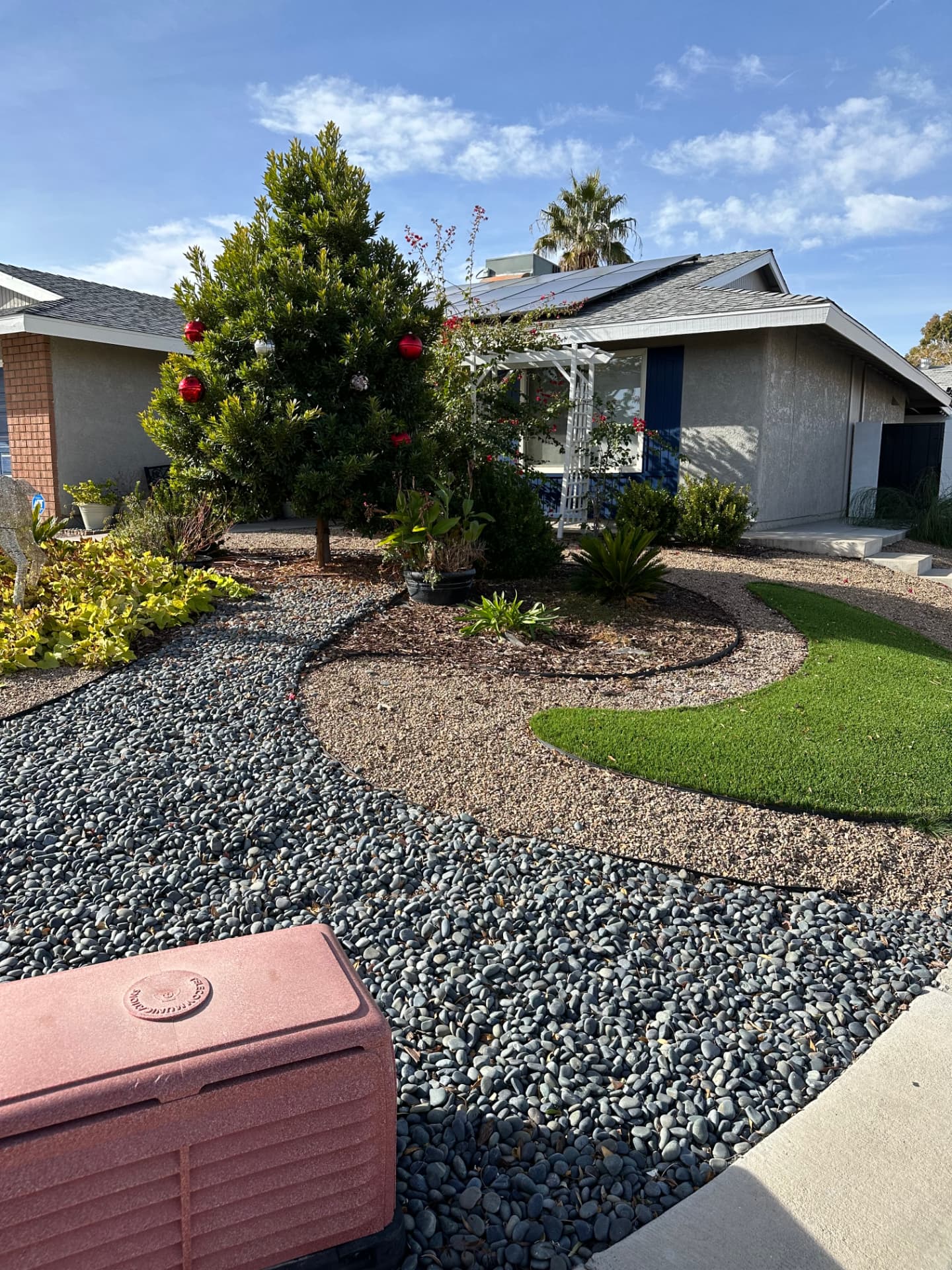 Finished front yard with curved river rock beds, decorative gravel and turf lawn