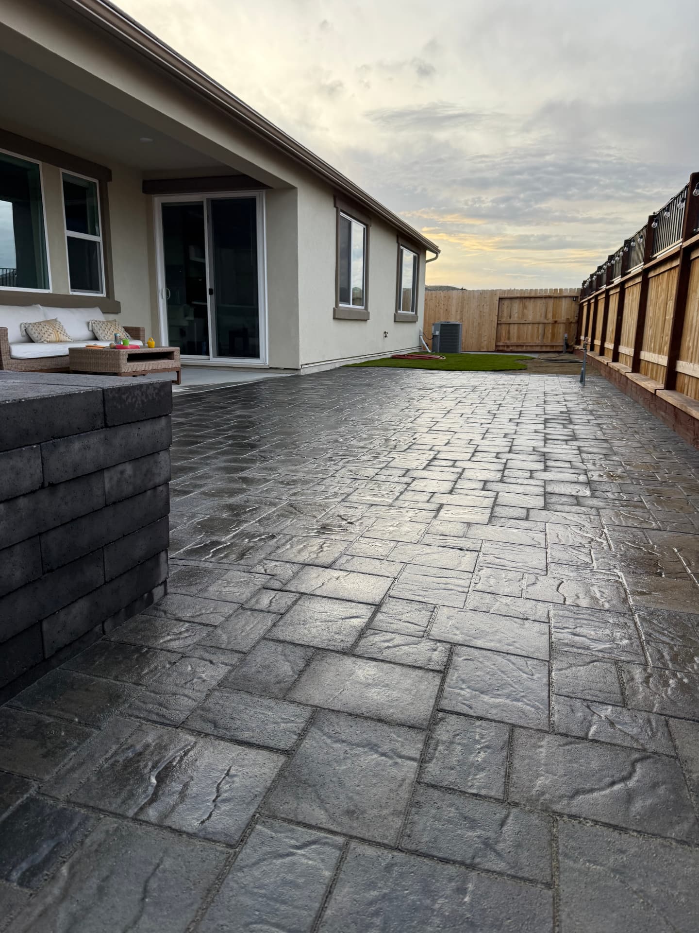 Large finished stamped paver patio at sunset