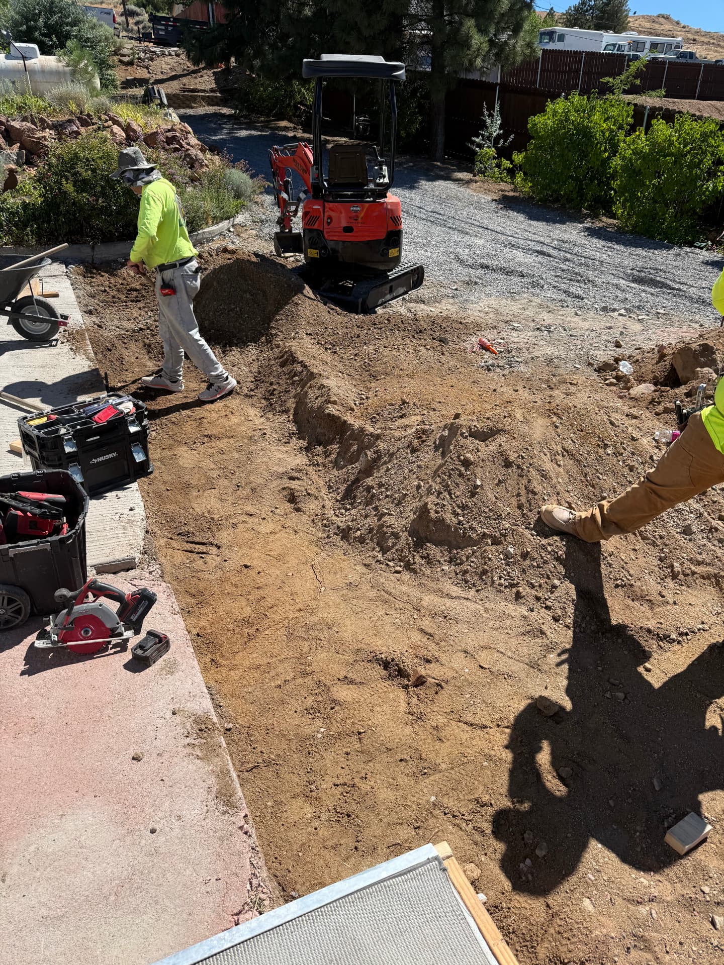 Crew excavating with a mini excavator during the concrete project