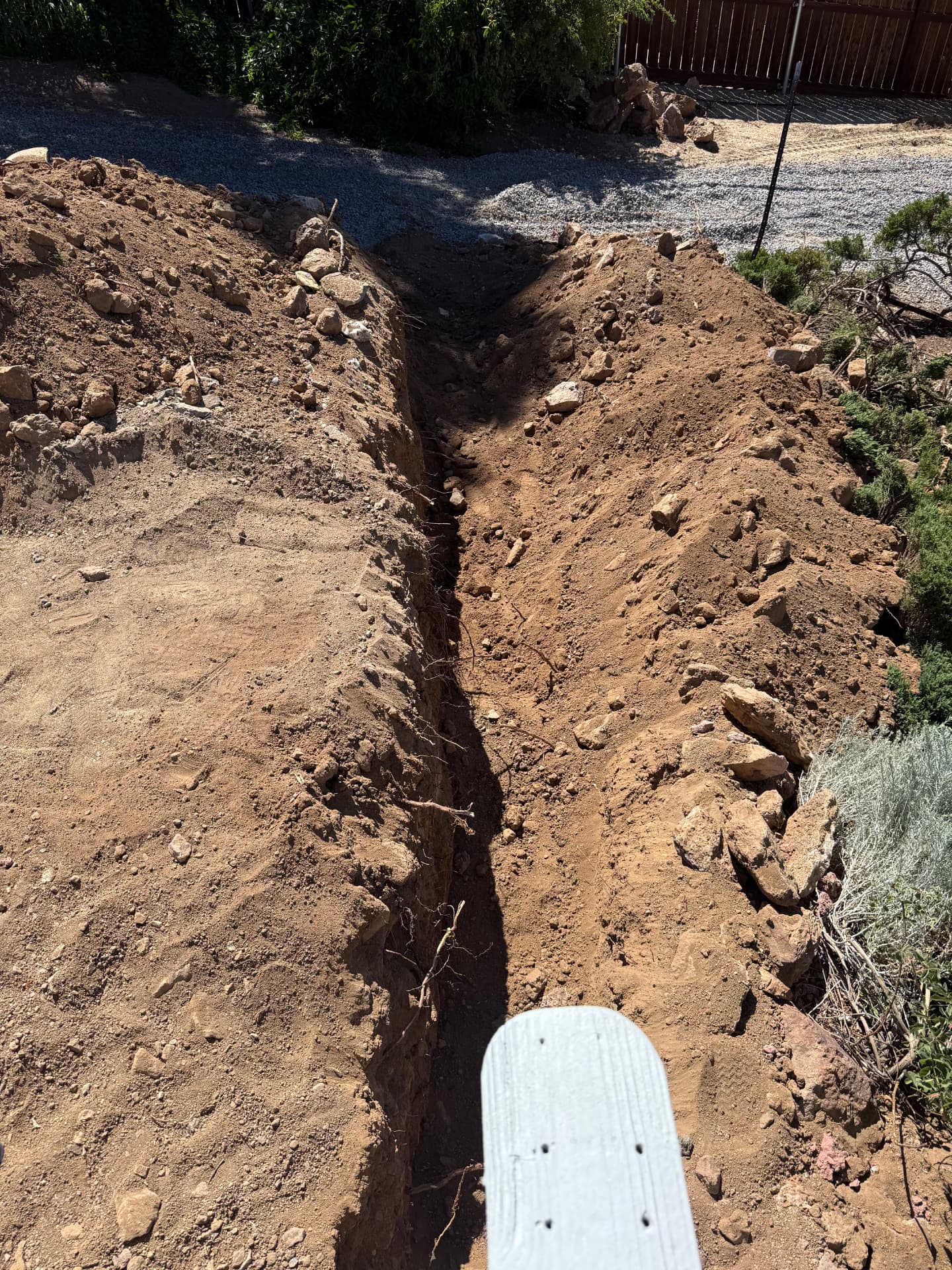 Trench dug along the property line for the new concrete work