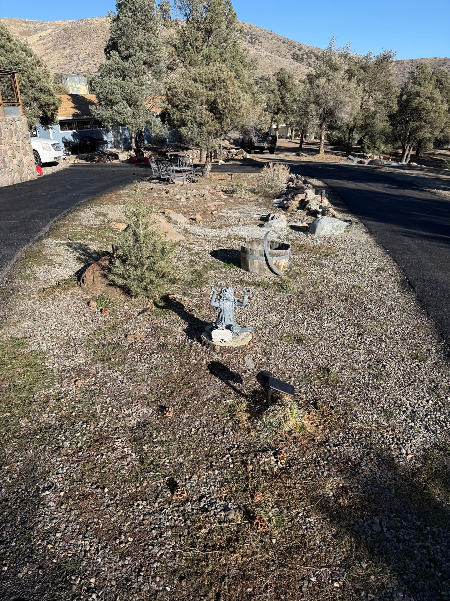 Gravel and weed island in a circular driveway before hardscape work