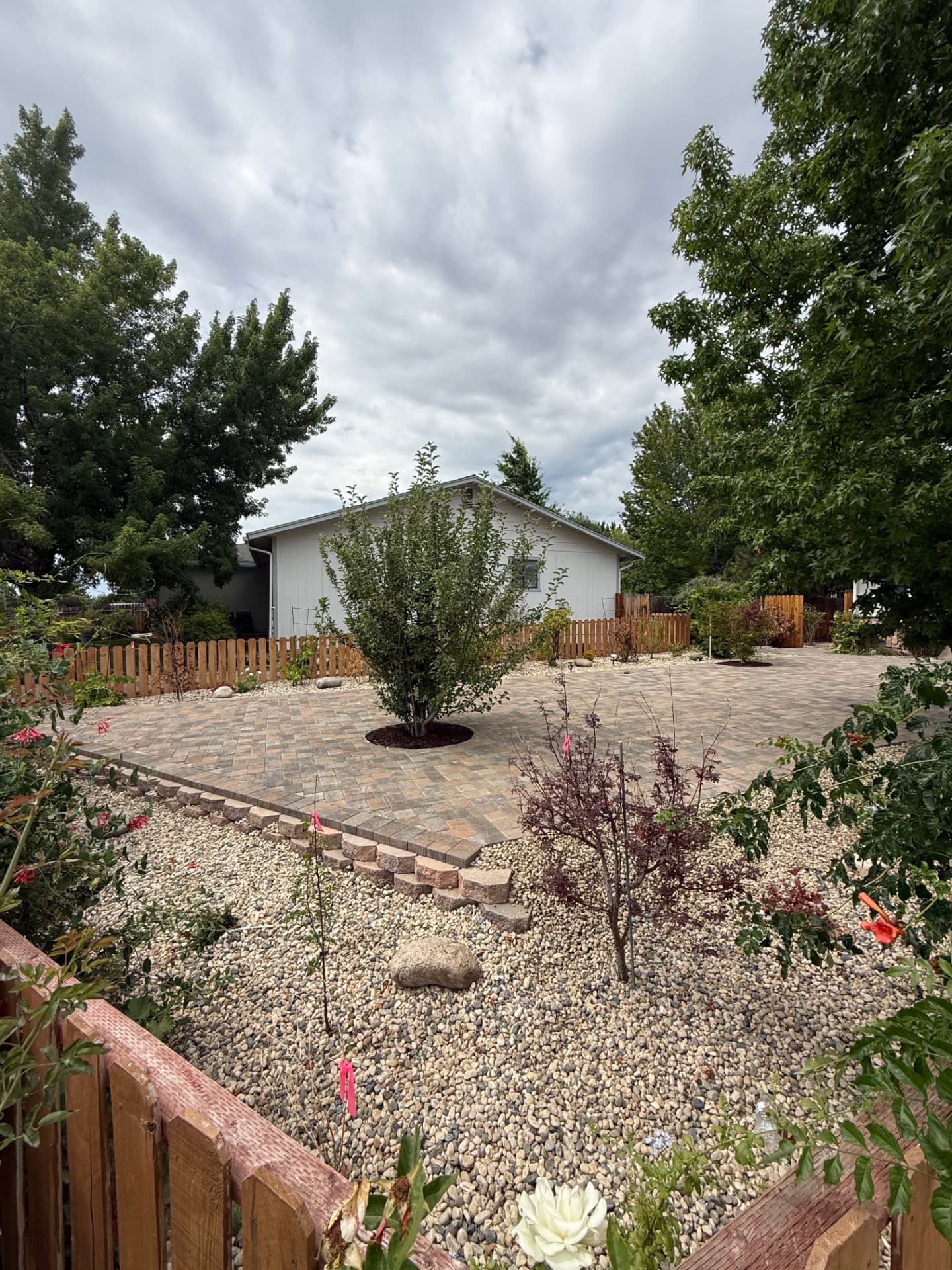 Wide view of the finished paver patio and rock landscaping
