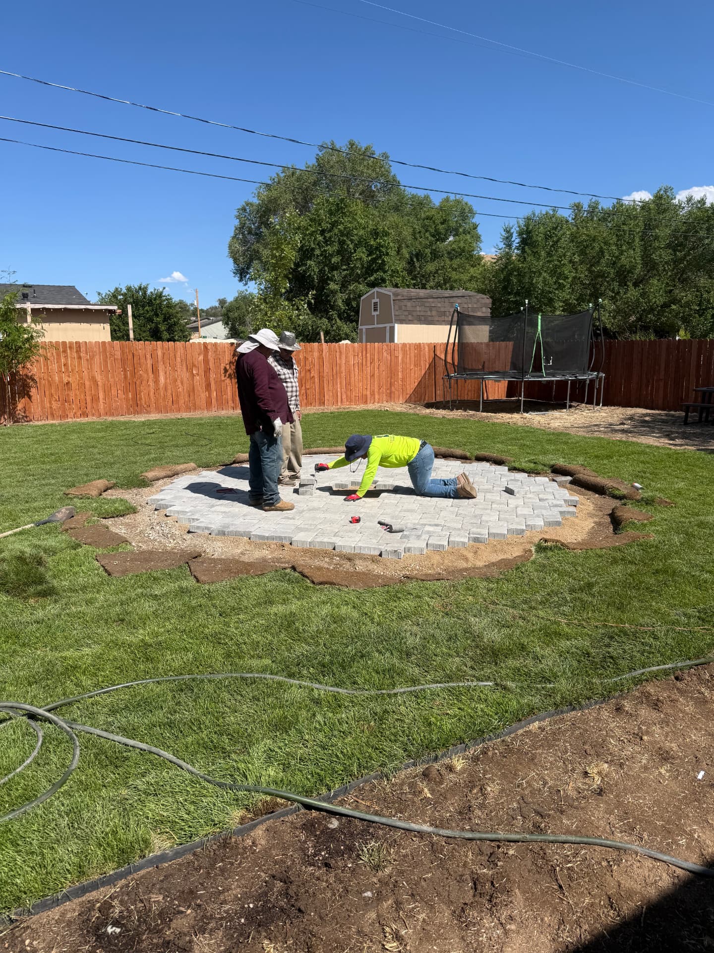 Paver patio taking shape in the middle of the new lawn