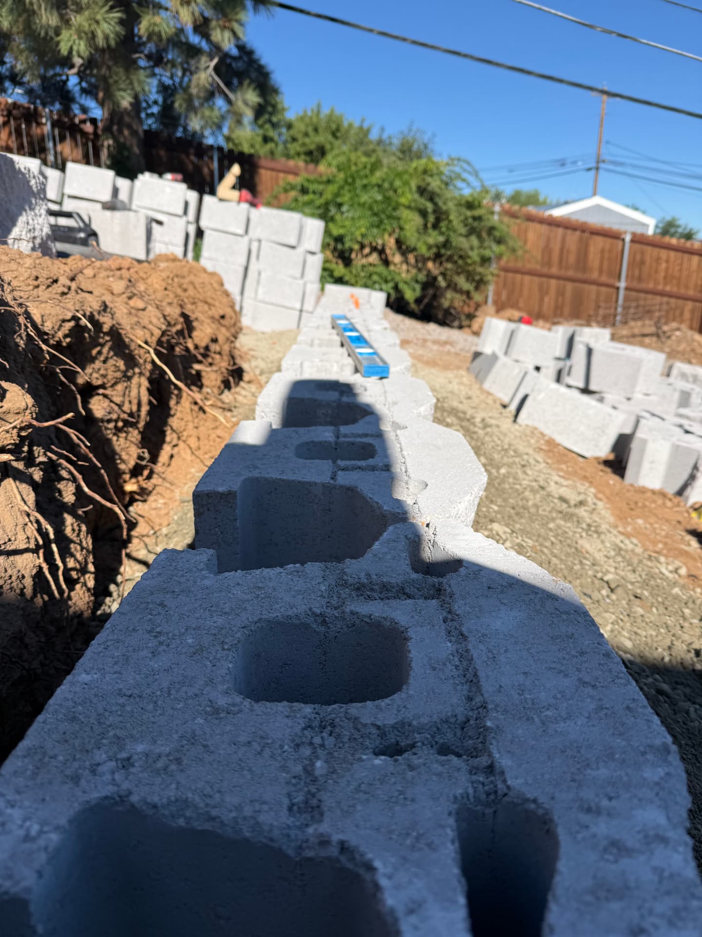 First course of retaining block set and leveled in the trench