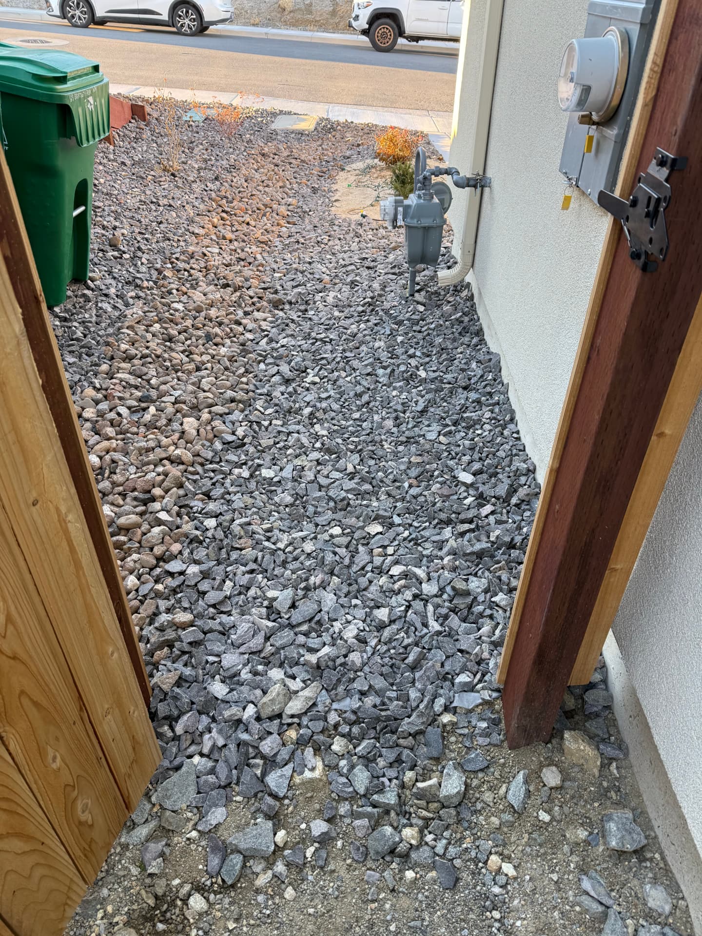 Side yard covered in mixed gravel before the new hardscape