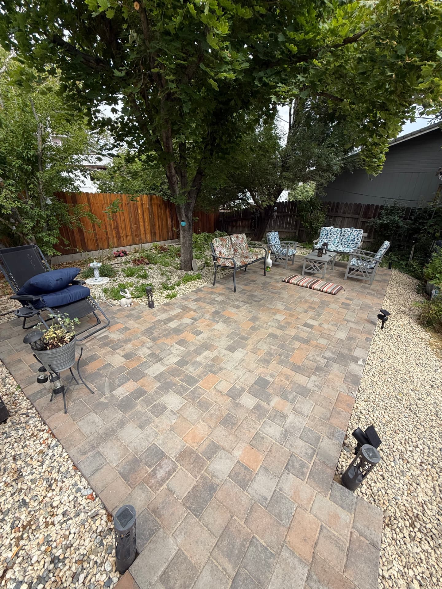 Completed backyard paver patio furnished with outdoor seating