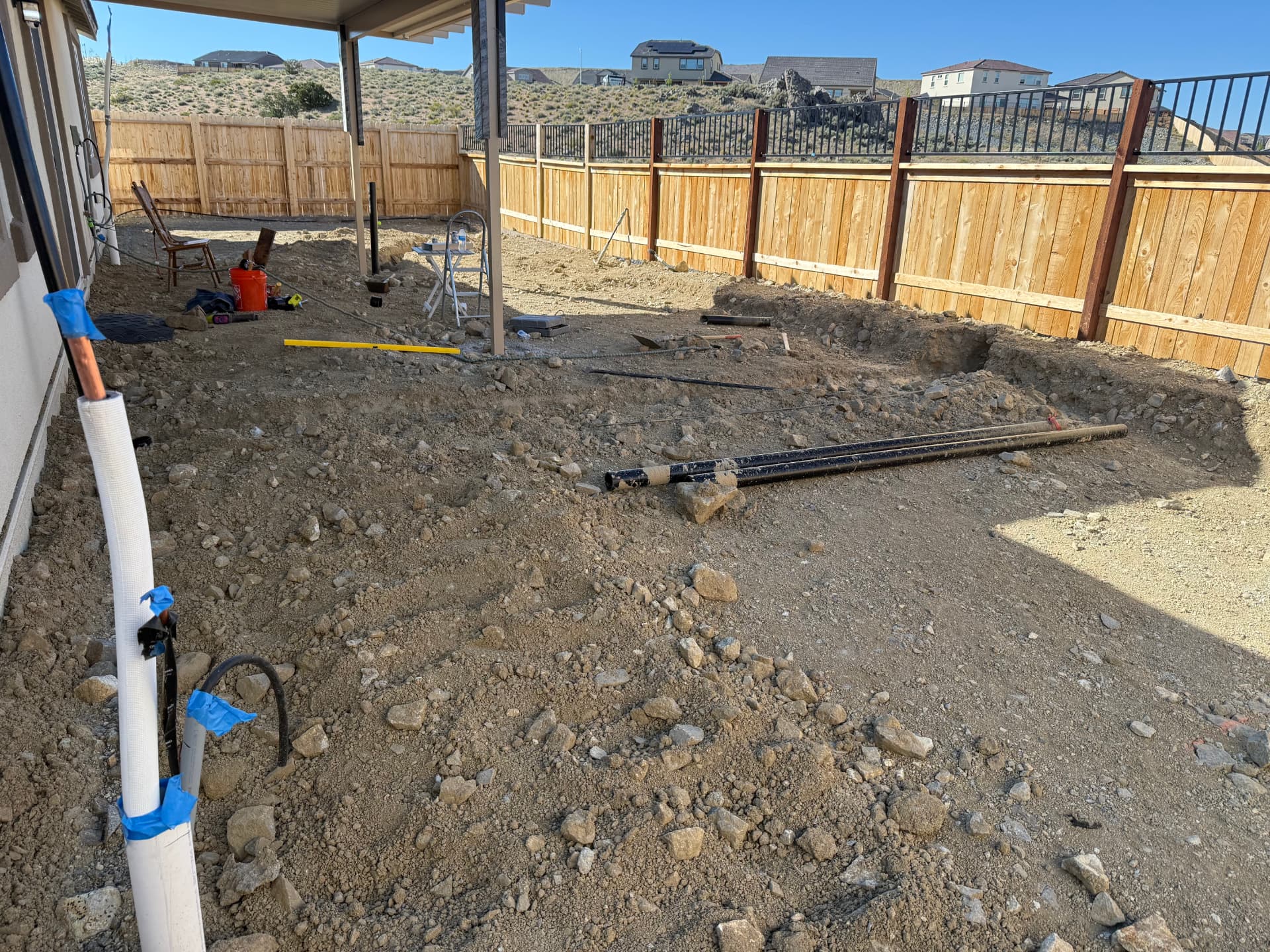 Backyard excavated and trenched for utilities under the new patio cover