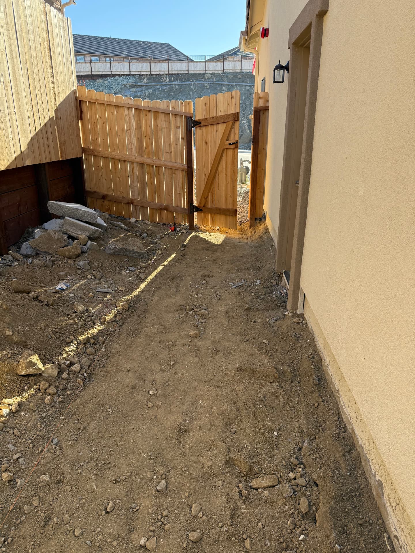 Side yard dirt run leading to the new cedar gate before construction