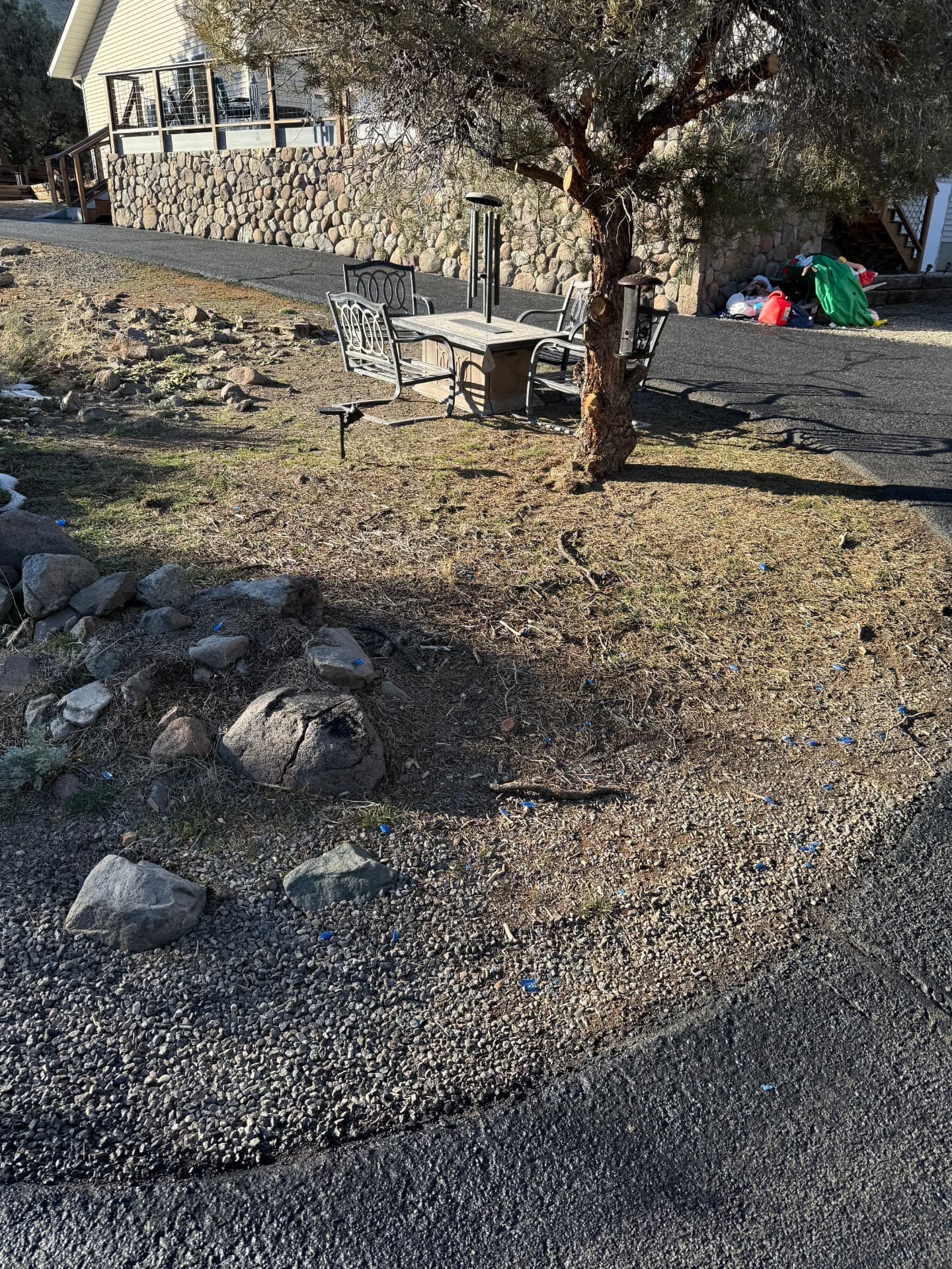 Bare yard with rock fire ring and dry grass before the project