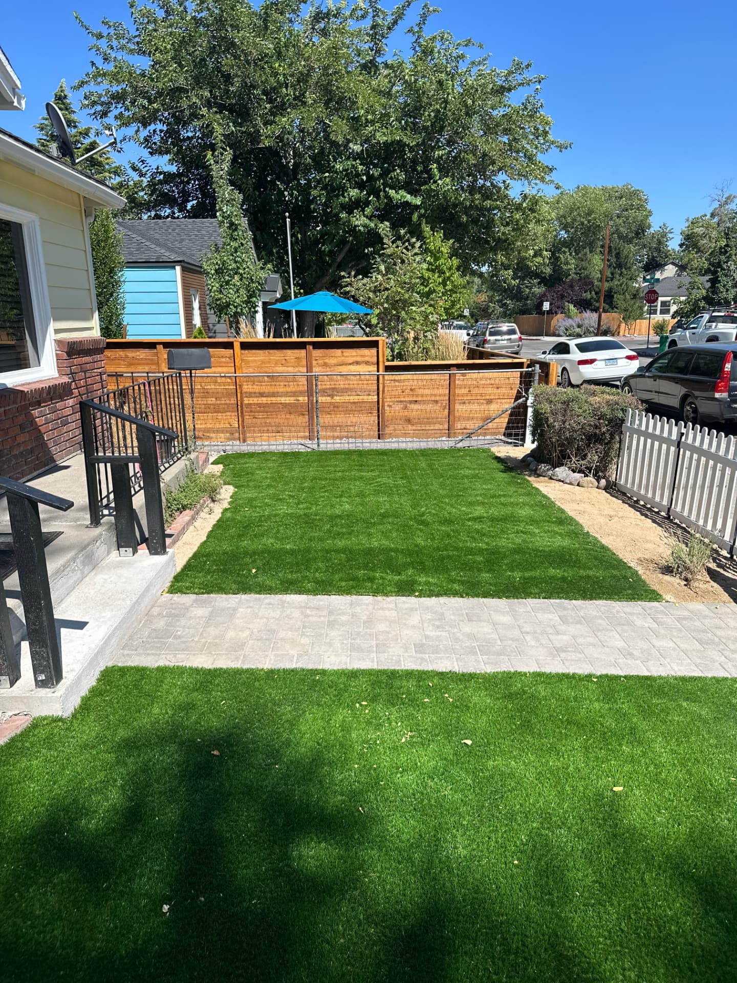Completed backyard with synthetic turf, paver path and cedar privacy fence
