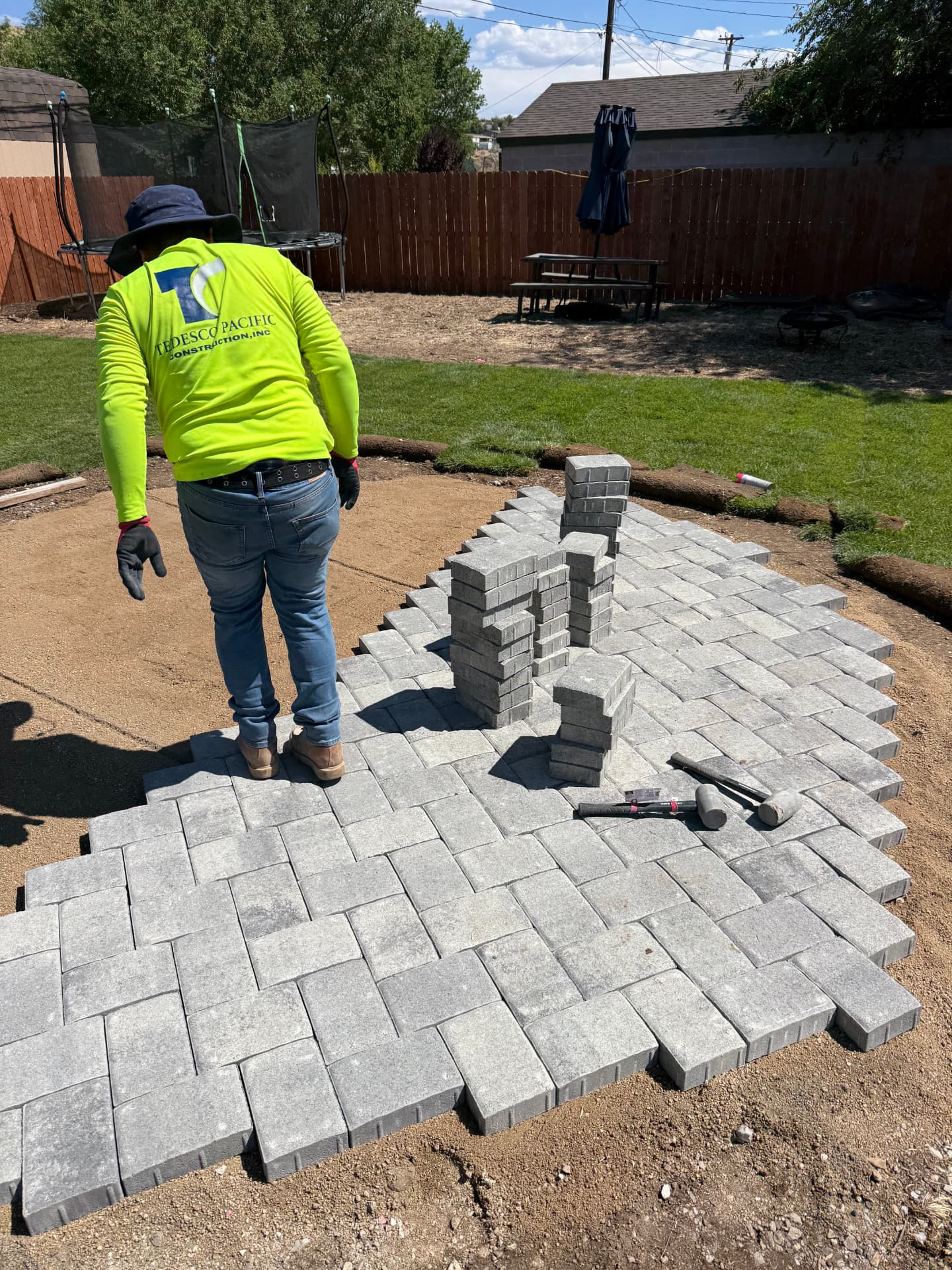Crew laying herringbone pavers on the circular patio