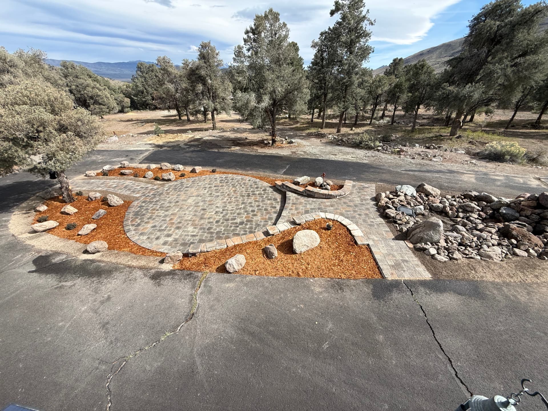 Aerial view of the finished driveway island patio, walls, and landscaping
