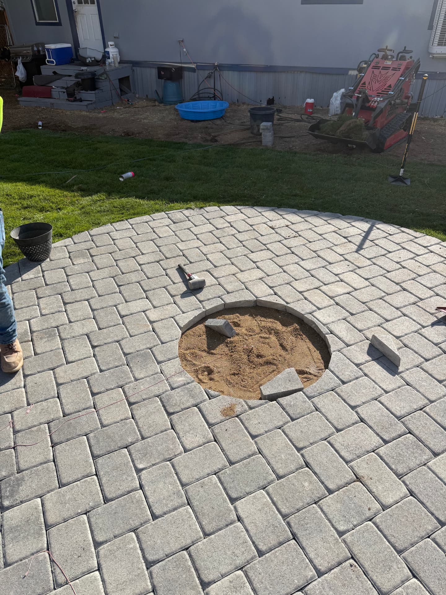 Circular paver patio with fire pit opening cut in the center