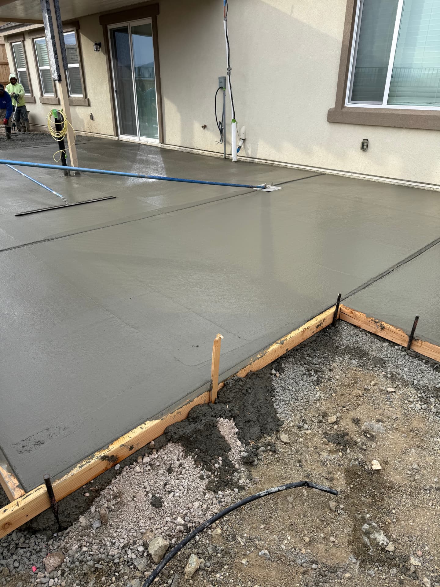 Freshly floated concrete patio slab against the house