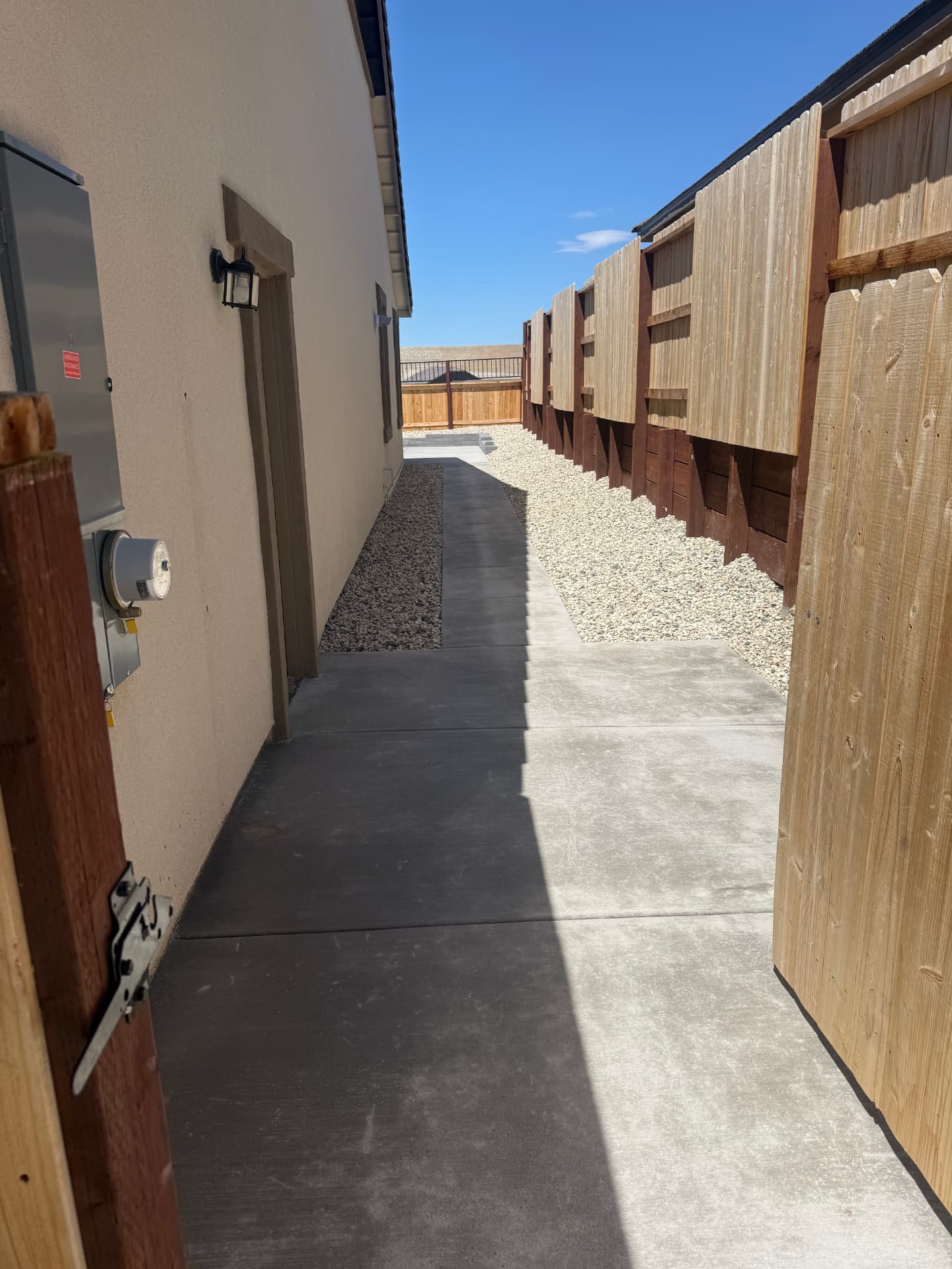 Finished side yard concrete walkway with decorative rock beds