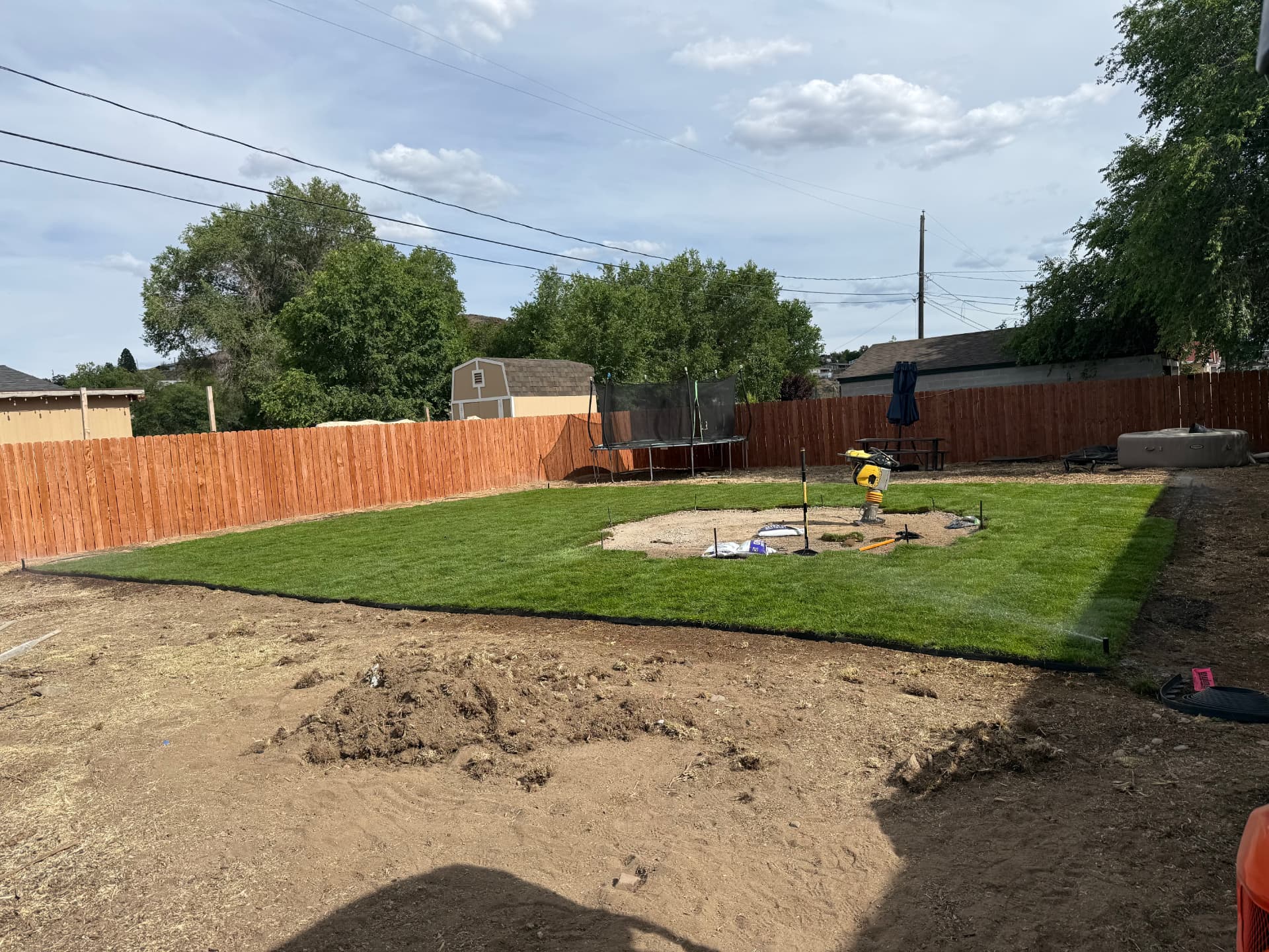 Fresh sod installed around the prepared patio base