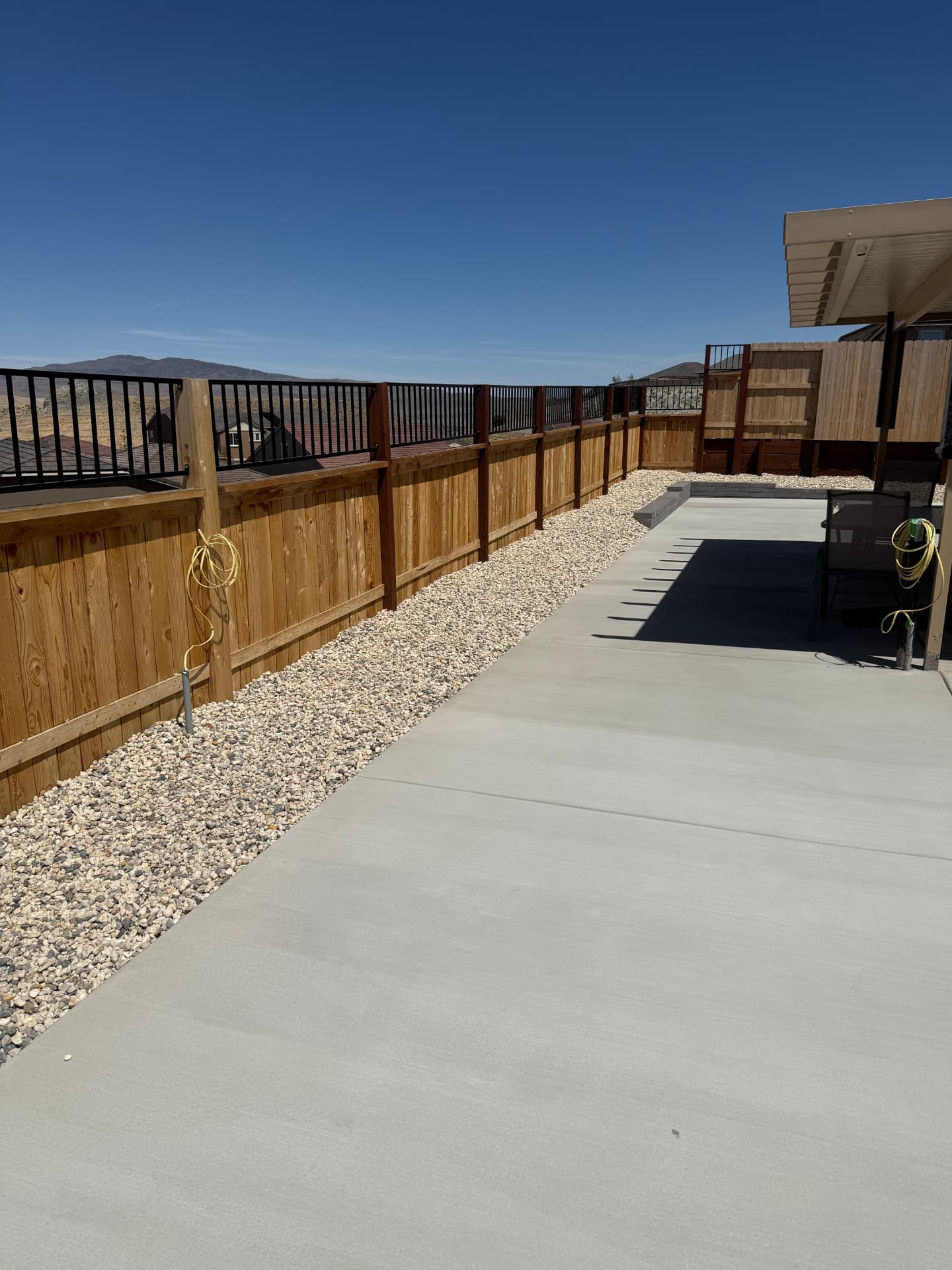 Finished patio and gravel border running the length of the fence