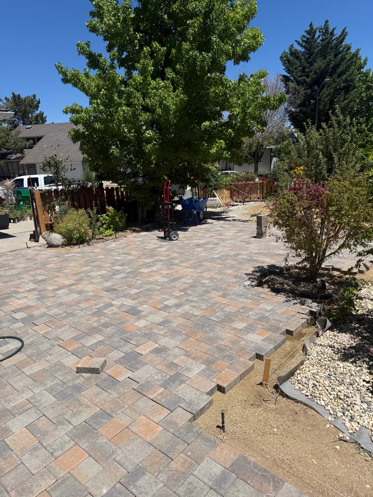 Large front paver patio mid-installation with block edging