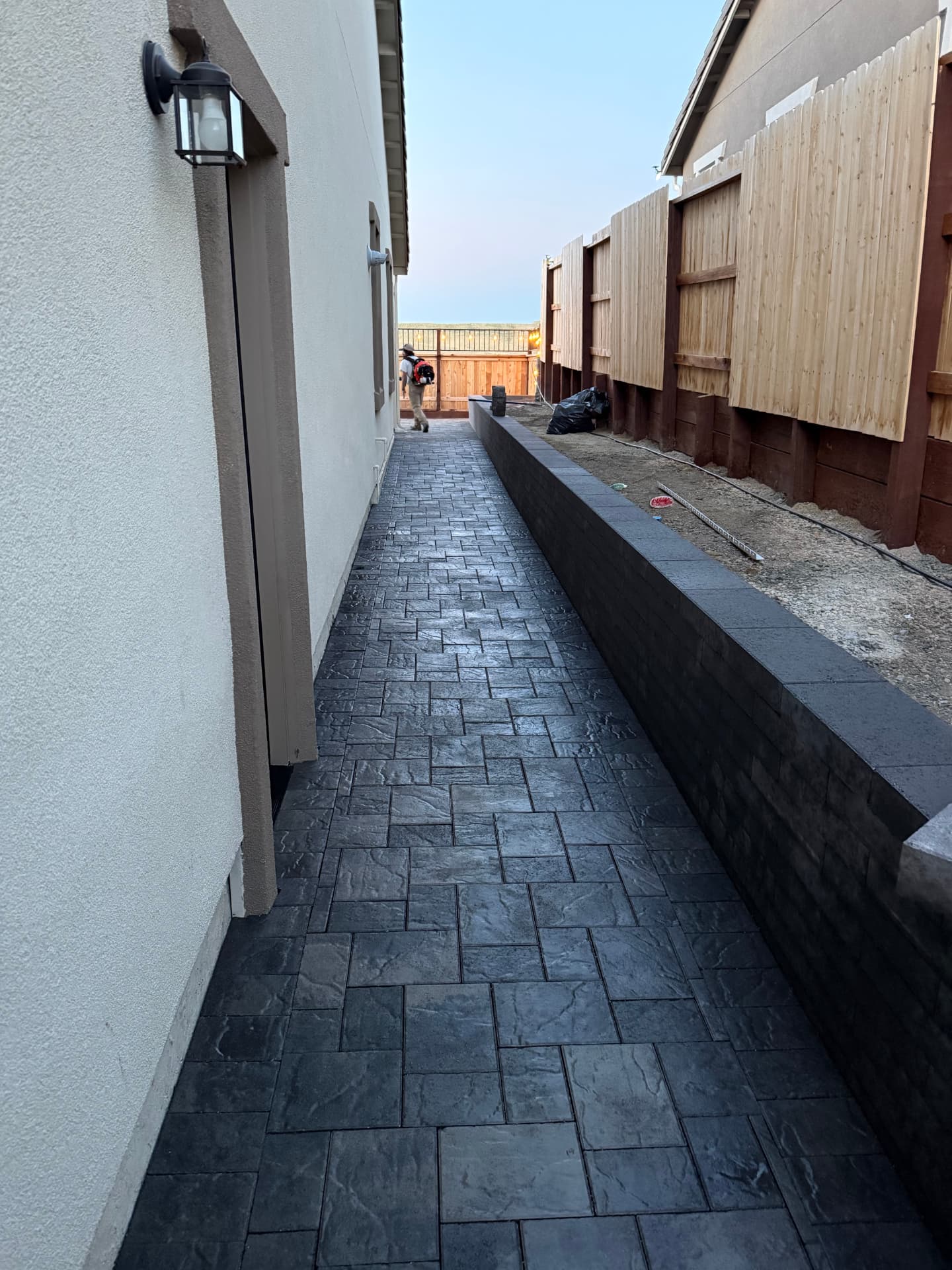 Stamped paver side yard walkway with charcoal seat wall