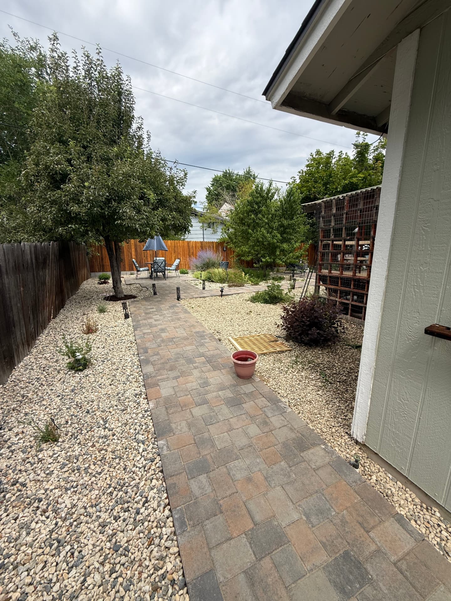 Long paver pathway leading to the finished backyard patio