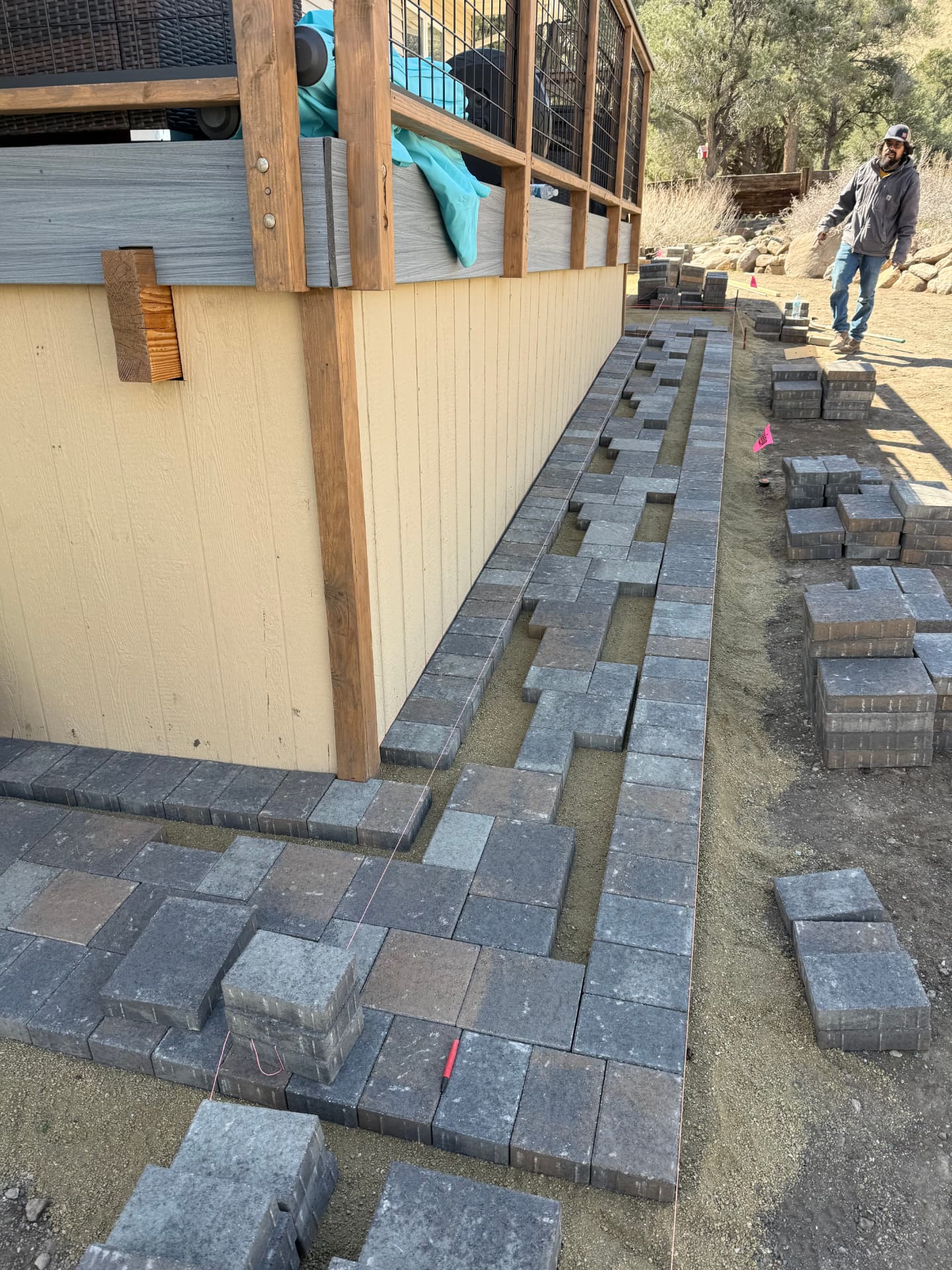 Crew setting the paver border and soldier course along the house