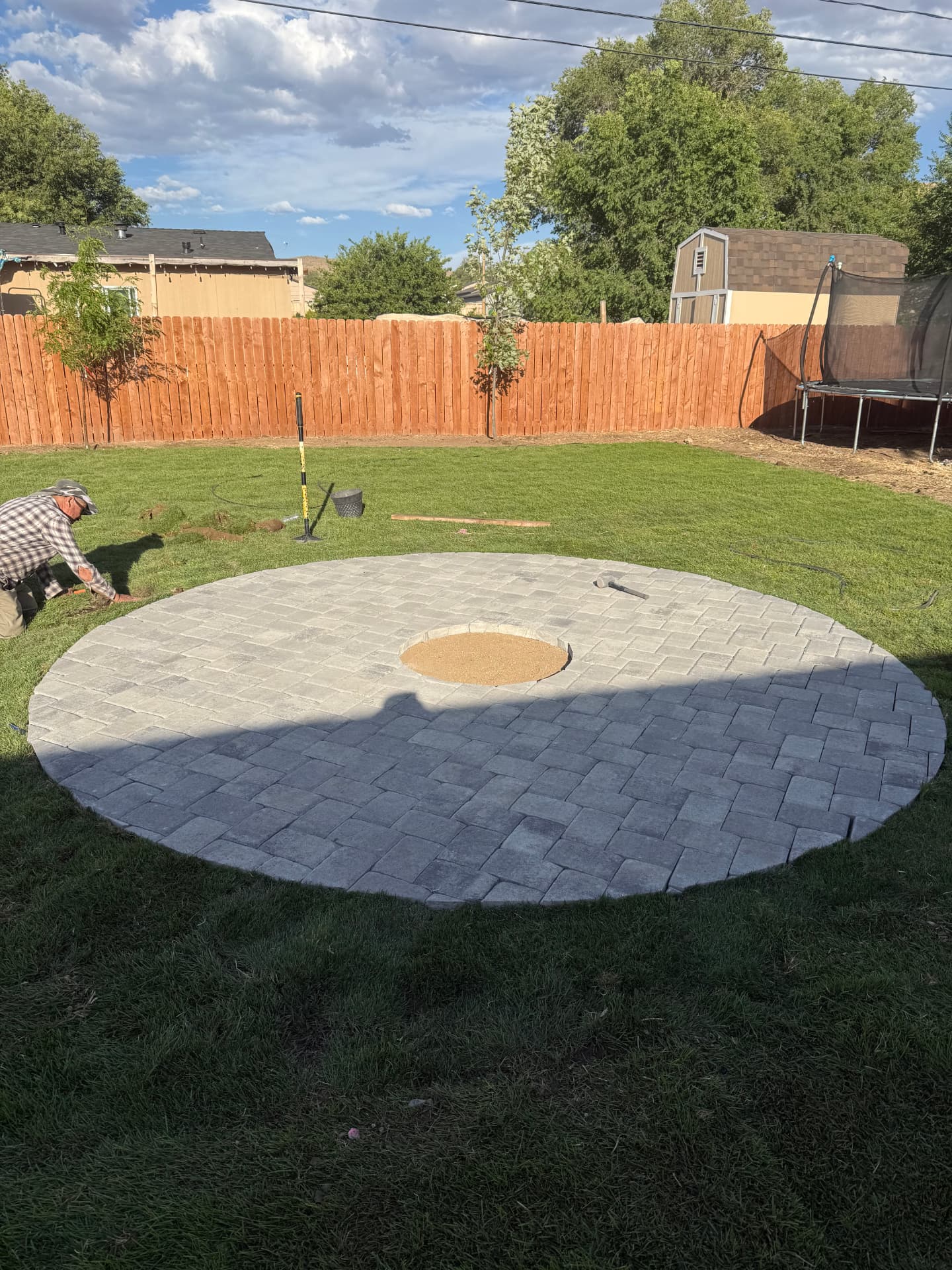 Completed circular paver patio with fire pit ring in the center