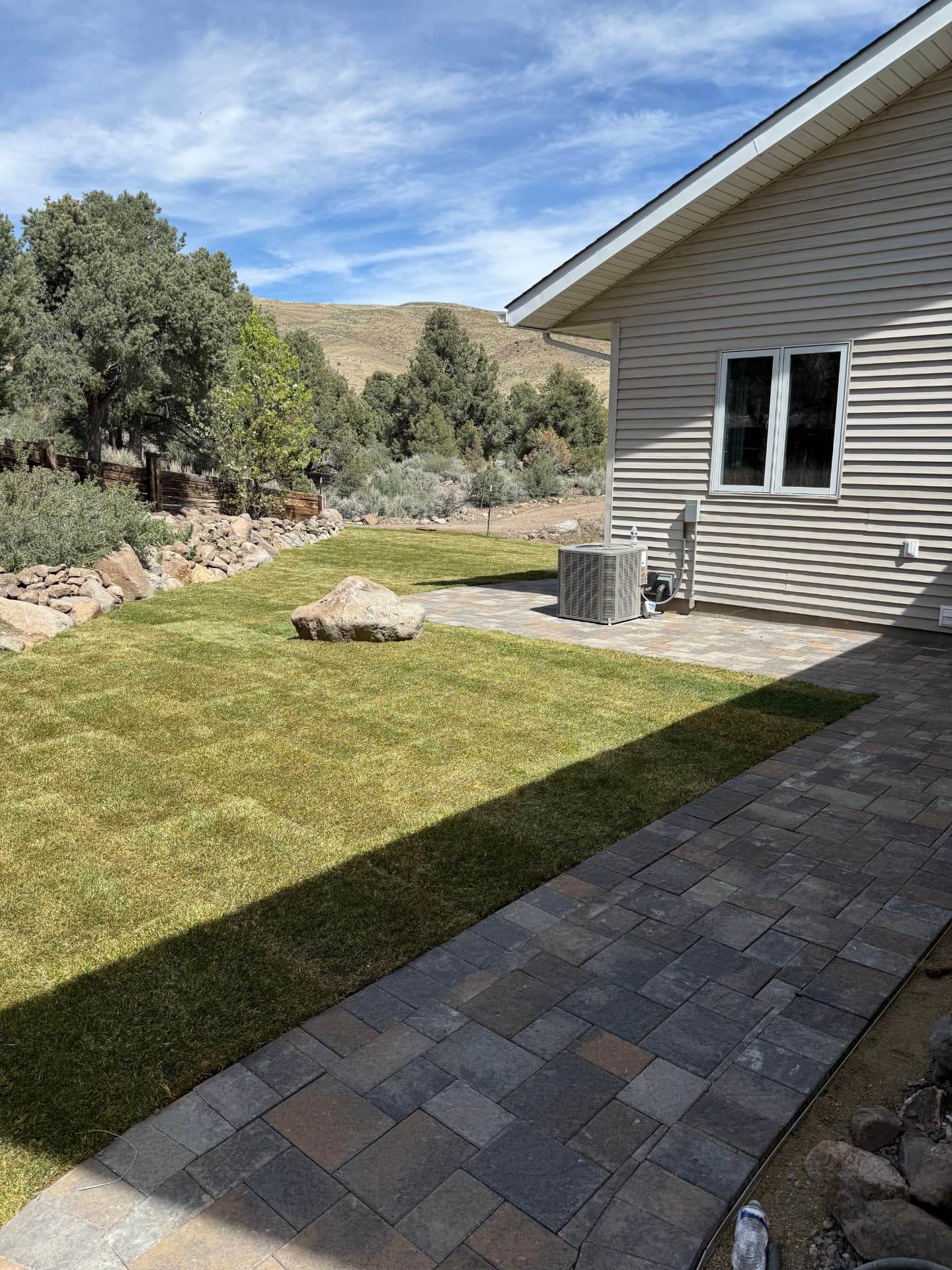 New sod lawn and paver walkway along the side of the house