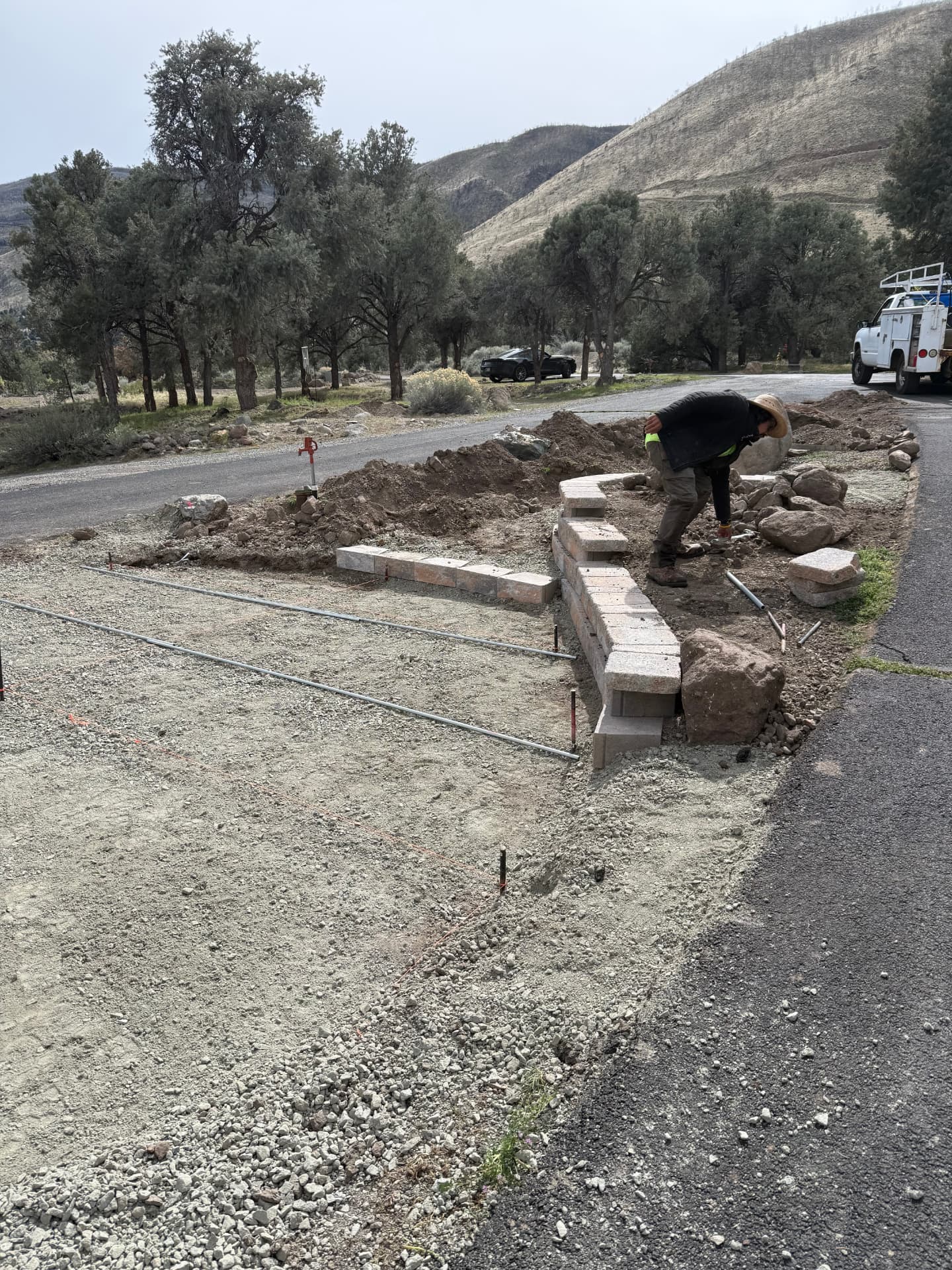 New block retaining wall and steps set along the driveway edge